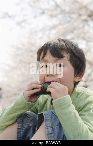 Japanische junge Sushi-Essen und Blick in die Kamera Stockfoto