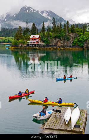 Kajakfahrer vorbeifahren ein Schwimmdock in Halibut Cove in Kachemak Bay, Yunan Alaska im Sommer Stockfoto