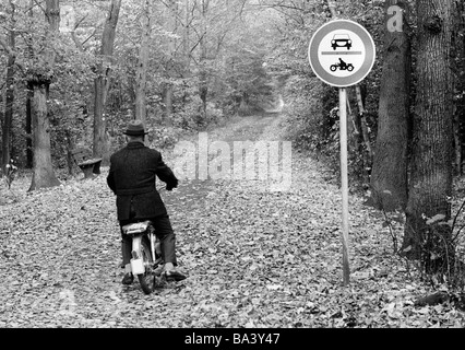 70er Jahre, schwarz / weiß Foto, Herbst, Wald, Wald, Straße, Verbotszeichen, kein Eintrag für Autos und Motorräder, dennoch ein älterer Mann auf einem Moped durchläuft, im Alter von 60 bis 70 Jahre, D-Bottrop, D-Bottrop-Kirchhellen, Grafenwald, Ruhrgebiet, Nordrhein-Westfalen Stockfoto