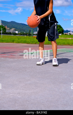 Teenager, die niedrige Basketballsektion werfen wird vorbereitet Stockfoto