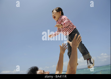 Vater heben Kind in Luft Stockfoto