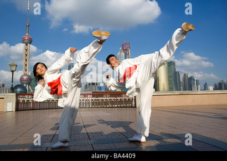 Junger Mann und Frau tun Martial Arts auf den Bund Stockfoto