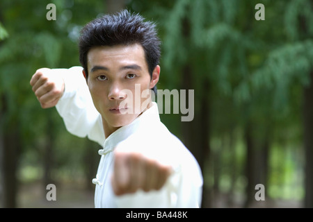 Junger Mann mit Kampfkunst, die einheitliche Durchführung der Kung Fu Stanzen Stockfoto