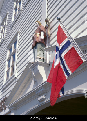 Geschnitzten und bemalten hölzernen Engelsfigur und Flagge auf einem alten Holz Waterfront Lager, Bryggen, Bergen, Hordaland, Norwegen. Stockfoto