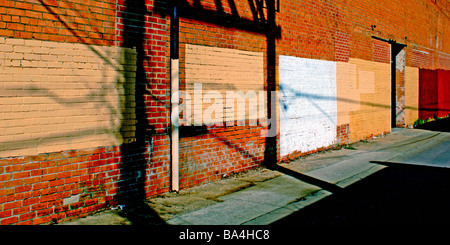 Schatten und Farbe Quadrate auf eine Mauer in einer Nachbarschaft-Gasse Stockfoto