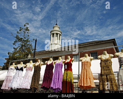 Kleider für den Verkauf auf armlosen Schaufensterpuppen hängen Rack mit blauen Himmel und Regierung Postgebäude in bunten Hintergrund Stockfoto