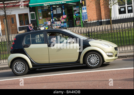 Seitenansicht eines Mercedes Smart Forfour Autos wird angetrieben von einem Frau-Fahrer entlang einer Straße von London, England Stockfoto