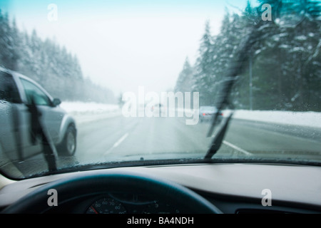 Autofahren in Stoßstange an Stoßstange Verkehr durch die Berge in einem Regen-Schnee-Sturm Stockfoto