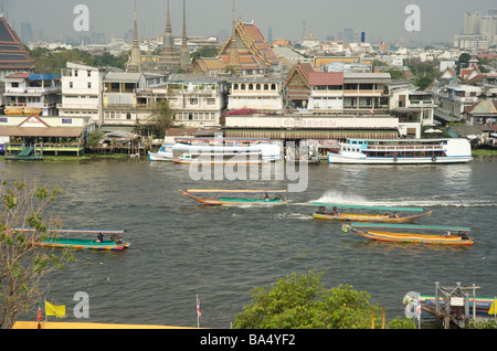 Lange Taxiservice Boote passieren den Tempel von Wat Pho auf dem Chao Phraya Fluss Bangkok Thailand Stockfoto