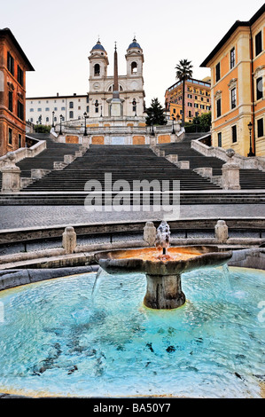 Detail der Fontana della Barcaccia in Piazza di Spagna mit der spanischen Treppe und der Kirche der Trinità dei Monti über Stockfoto