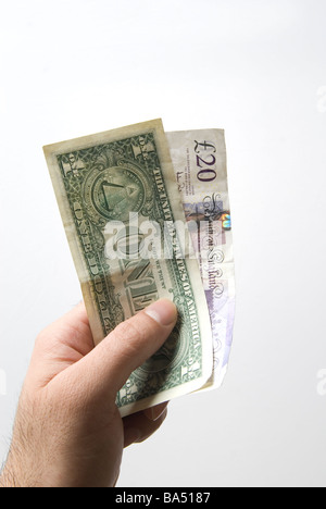 Hand, die eine amerikanische eine Dollarnote und zwanzig Pfund britische Banknoten Stockfoto