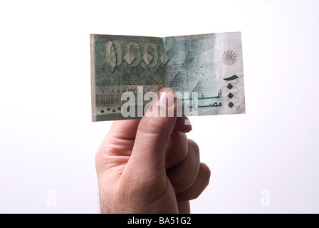 Hand, die libanesische tausend Lira Banknote vor einem weißen Hintergrund Stockfoto