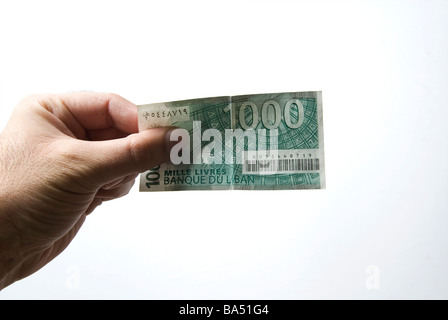 Hand, die libanesische tausend Lira Banknote vor einem weißen Hintergrund Stockfoto