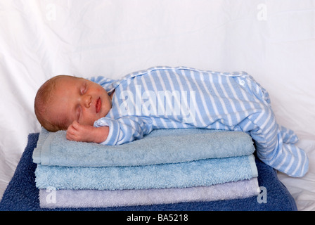 Baby schläft auf Stapel von gefaltete Handtücher Stockfoto