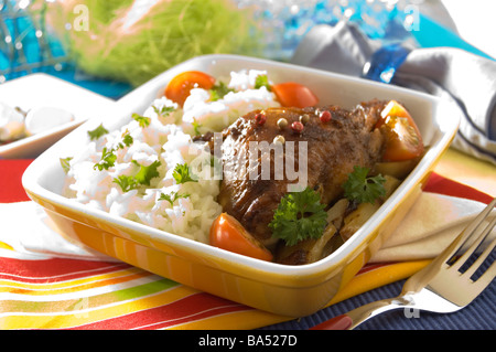 Gratinierte Hühnerbein in einem Ofen, serviert mit Reis und Tomaten Stockfoto
