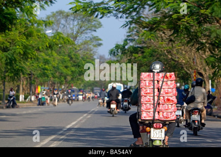 Vietnamesische Mann transportiert Fälle von Coca Cola auf der Rückseite von seinem Motorrad auf dem National Highway 1 in Hue, Vietnam Stockfoto