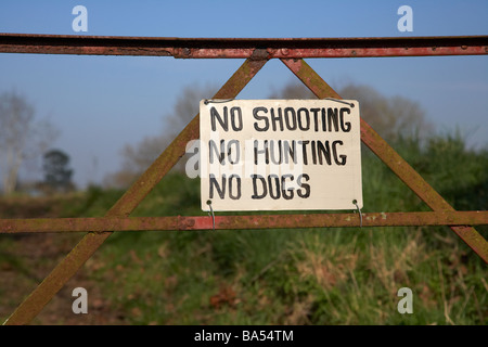 kein schießen keine Jagd keine Hunde einen alten rostigen Metall Tor Eingang zu einem Feld anmelden Stockfoto