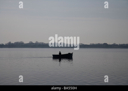 kleine einzelne einsamen Fischer ausgehen in einem kleinen motorisierten Angelboot/Fischerboot am Lough Neagh Grafschaft Armagh Nordirland Stockfoto