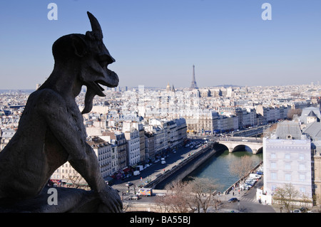 Kathedrale Notre Dame Gargoyle Paris Skyline Eiffelturm seine Paris Frankreich | PARIS, Frankreich — Ein Steinchimera auf den Türmen der Notre-Dame de Paris blickt auf die seine und die Dächer der Île de la Cité, mit Blick auf den Eiffelturm am Horizont. Diese grotesken Figuren wurden der Kathedrale während der Restaurierung von Eugène Viollet-le-Duc aus dem 19. Jahrhundert hinzugefügt, anstatt vom mittelalterlichen Bau zu erhalten. Der 1889 fertiggestellte Eiffelturm ist 1.083 Fuß (330 m) hoch, einschließlich seiner Antenne. Stockfoto