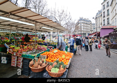 PARIS, Frankreich — Markt für frische Produkte in der Rue Mouffetard im 5. Arrondissement von Paris. Der Markt, der für seine lebhafte Atmosphäre bekannt ist, bietet Verkaufsstände voller farbenfroher Früchte, Gemüse und anderer lokaler Produkte. Käufer und Händler tauschen sich lebhaft aus und tragen so zum historischen Charme und zur lebhaften Energie der Straße bei. Stockfoto