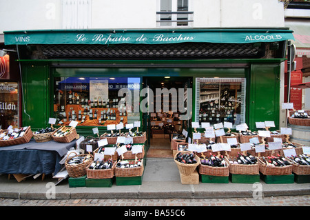Weinhandlung Le Repaire de Bacchus Grüne Fassade Mouffetard Street Paris Frankreich // PARIS, Frankreich — die französische Weinhandlung Le Repaire de Bacchus mit ihrer unverwechselbaren grünen Fassade bietet zahlreiche Weinkörbe auf dem Fußweg. Es liegt an der Rue Mouffetard (auch bekannt als Mouffetard Street) im historischen 5. Arrondissement von Paris. Diese Gegend ist Teil des Quartiers Latin, das für sein intellektuelles Erbe und das pulsierende Straßenleben bekannt ist. Die einladende Flaschenpräsentation schafft eine typische Pariser Straßenszene, die für die charmanten Geschäftsviertel der Stadt charakteristisch ist. Stockfoto