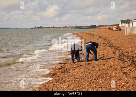 Ein paar suchen Strand an HIll Spitze am Southampton Water für interessante Muscheln Stockfoto