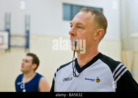 Schiedsrichter mit Pfiff um Basketball-match Stockfoto