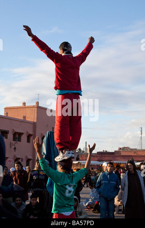 Lokalen Akrobaten abenteuerliche gymnastische gewagte Stunts ausführen, große Menschenmengen, unterhalten Platz Jemaa el Fna, Marrakesch Stockfoto