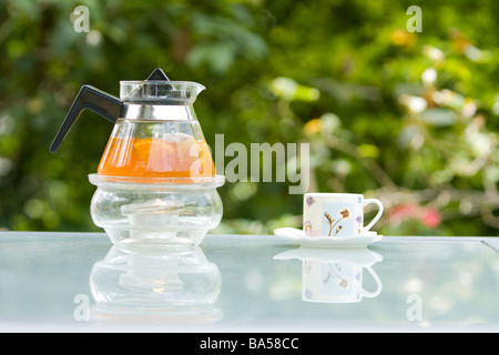 Taiwanesische style hot Orange und Apfel Obst Tee, Teekanne aus Glas mit Kerze Heizelement, transparente Schnellkochkanne mit Feuer Wärme, eine Teetasse Stockfoto