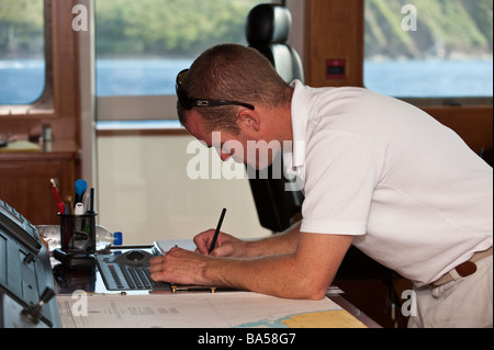 Chief Officer das Logbuch auf dem Kartentisch an Bord Superyacht "Großen Aron" verfassen Stockfoto