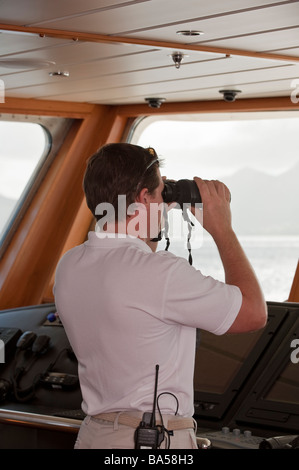 Kapitän auf der Brücke an Bord Superyacht "Großen Aron" Ausschau zu halten, mit dem Fernglas beobachten Stockfoto