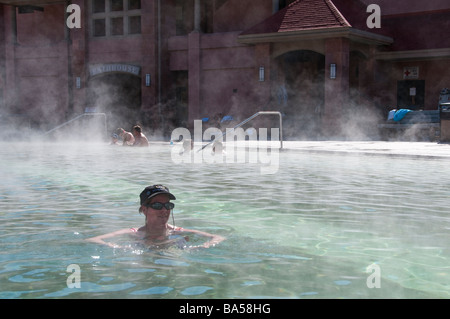 Frau saugt in den dampfenden Therapiebecken, Glenwood Hot Springs, Glenwood Springs, Colorado. Stockfoto