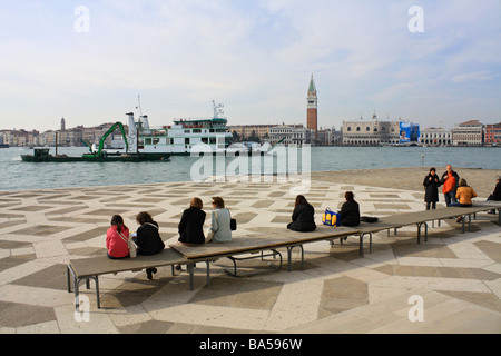 Touristen sitzen vor der Kirche San Giorgio Maggiore und den Blick wieder nach Venedig, Italien. Stockfoto