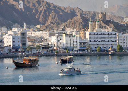 Schiffe am Ufer von Muttrah & Corniche Road Küste von Oman vor dem Hintergrund der historischen Hajar Bergkette und Forts Muscat Golf von Oman Asien Stockfoto