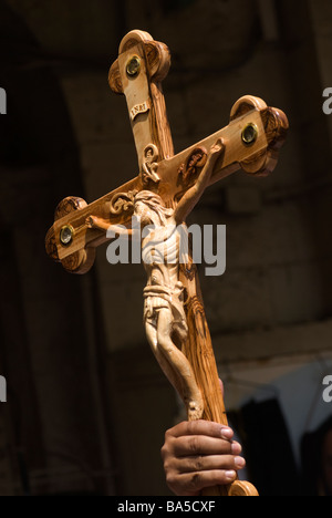 Ein christlicher Pilger hält Olivenholz Kreuz, als er entlang der Via Dolorosa alte Stadt von Ost-Jerusalem Israel Spaziergänge Stockfoto