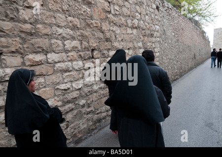 Israel. Altstadt von Jerusalem. Gruppe von Nonen in schwarz entlang der Wand in der Nähe von Zionstor Stockfoto