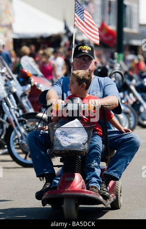 Älterer Mann gibt jungen Fahrt auf alten Personen drei Rad Fahrzeug jährliche Sturgis Motorcycle Rally South Dakota USA Stockfoto