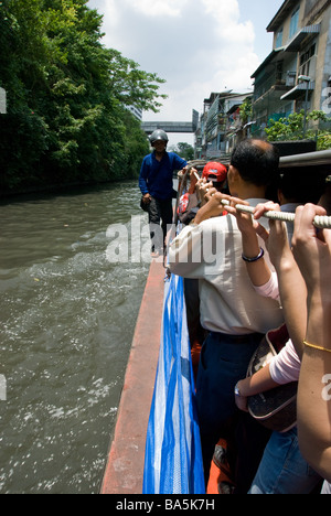 Passagiere, die auf ein Expressschiff am Saen Saeb Kanal durch Bangkok reisen Stockfoto