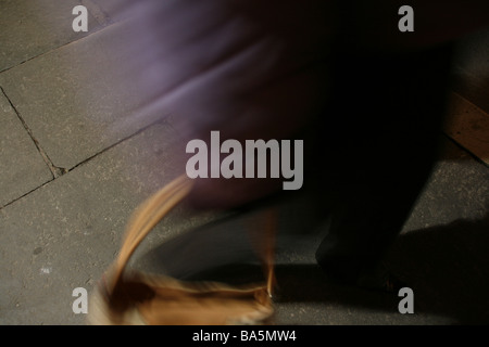 eine Person, die zu Fuß auf Straßenpflaster Stadt bei Nacht Stockfoto