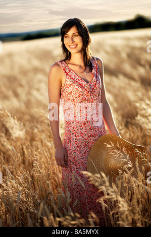 Schöne Frau im Feld halten Hütte stehend Stockfoto