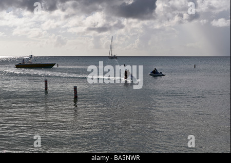 An Land kommen über Jetski am Pinneys Strand, Nevis, an einem stürmischen Nachmittag in der Karibik Stockfoto