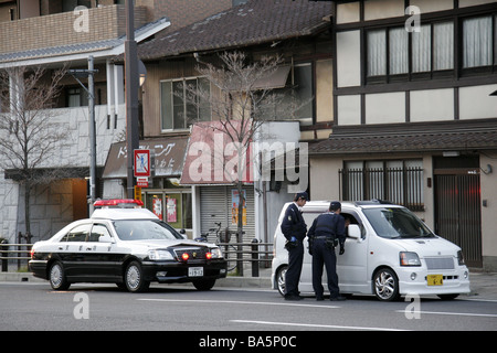 Japanische Polizei Offiziere im Gespräch mit dem Fahrer eines Autos in Kyoto Japan Stockfoto