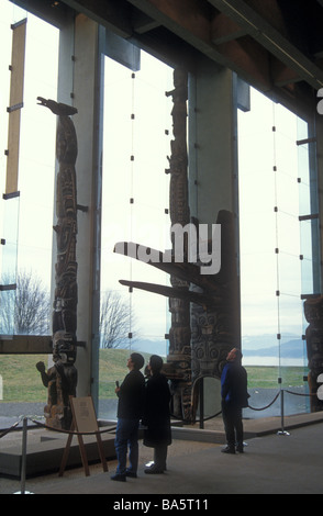 Touristen auf der Suche an Totempfähle im großen Saal des Museum of Anthropology, University of British Columbia, Vancouver Stockfoto