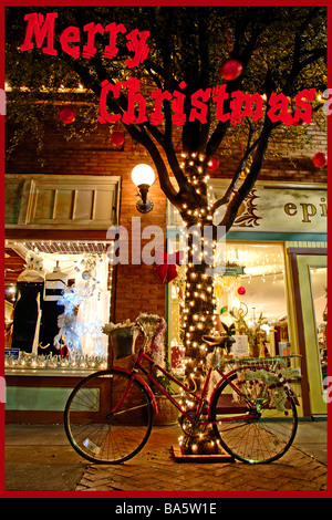 Hell erleuchtet Fahrrad gelehnt Baum mit Weihnachtsschmuck Stockfoto