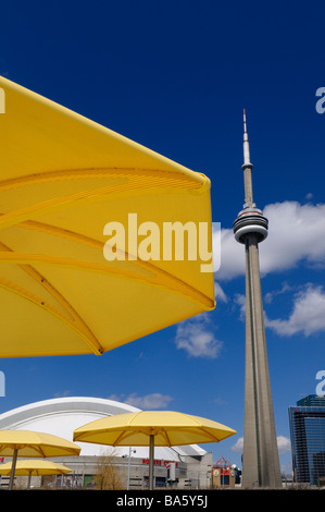 Gelbe Metall Sonnenschirme am städtischen Strand HTO Park mit CN Tower und das Rogers Centre Skydome Stadion Toronto Kanada Stockfoto