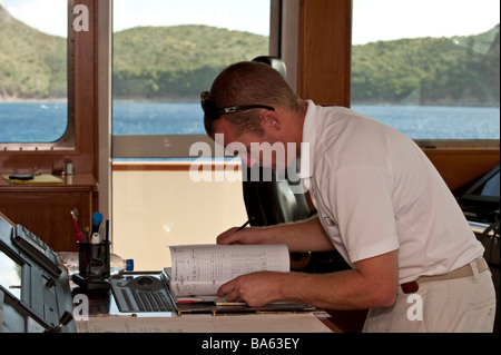 Chief Officer das Logbuch auf dem Kartentisch an Bord Superyacht "Großen Aron" verfassen Stockfoto