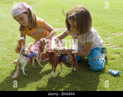 Wiese Mädchen zwei Barbie-Puppen keine Property-Release spielt Serie Leute Kinder Freundschaft Freunde Schwestern Zwillinge 6 Jahre Stockfoto