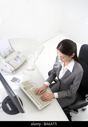 Geschäftsfrau, die Sie am Schreibtisch Draufsicht eingeben Stockfoto