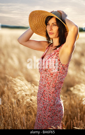 Schöne Frau im Feld halten Hütte stehend Stockfoto