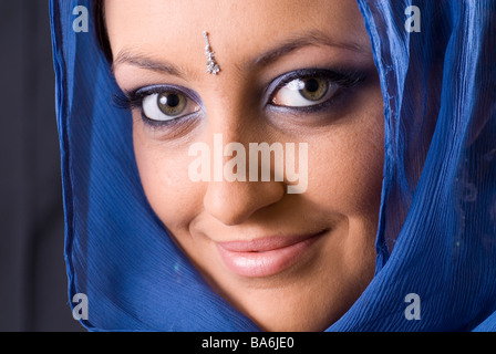 Schöne junge Frau trägt blaue Schal Stockfoto